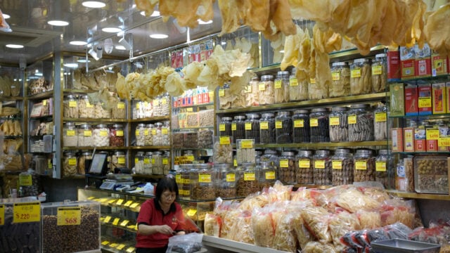 Woman at her dried food shop at the busy Dried food market in Sai Ying Pun, Hong Kong.